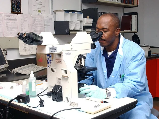 Citológiai szakasszisztens mikroszkóppal dolgozik egy felszerelt diagnosztikai laboratóriumban